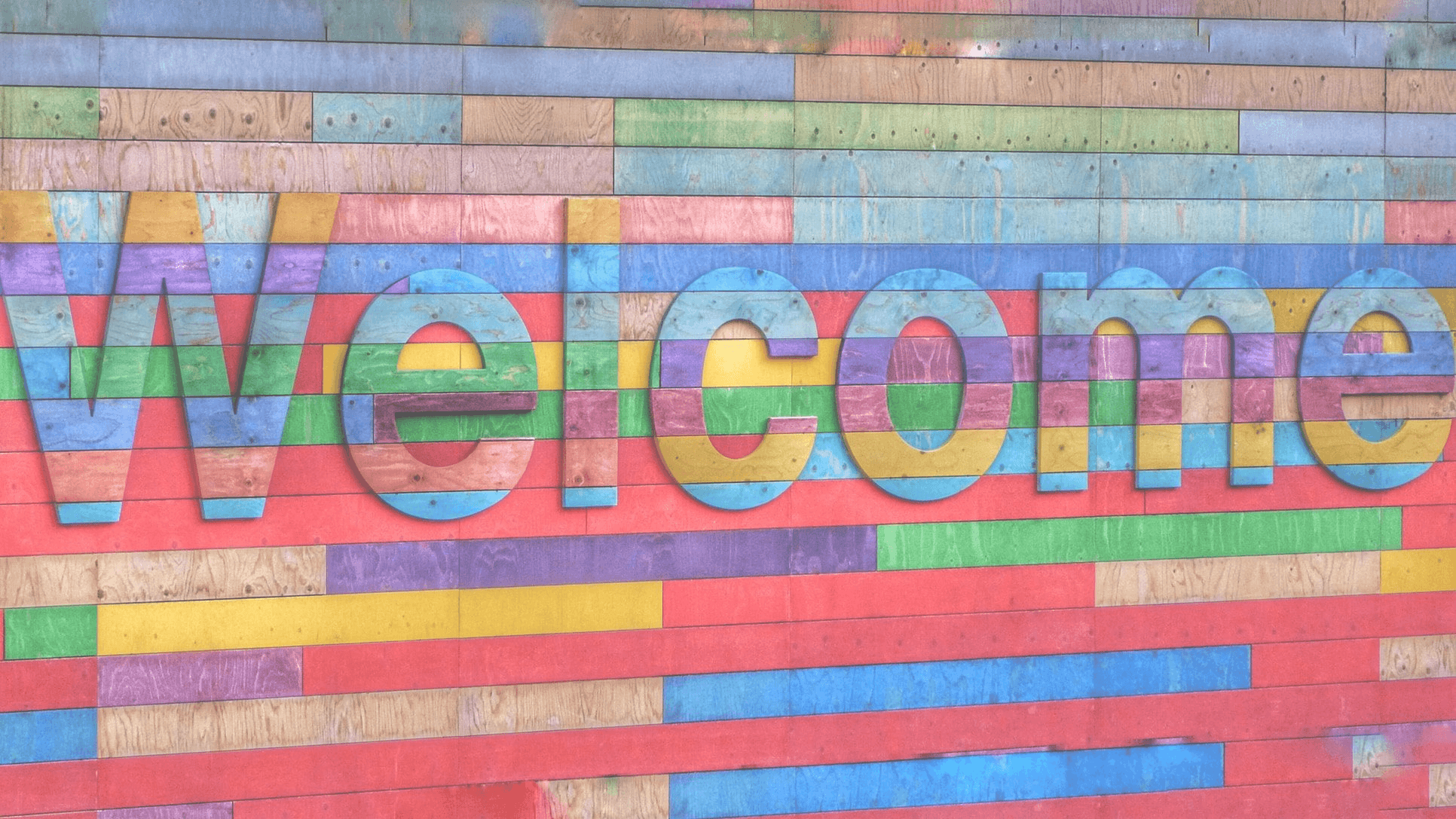 A wooden wall with the word welcome